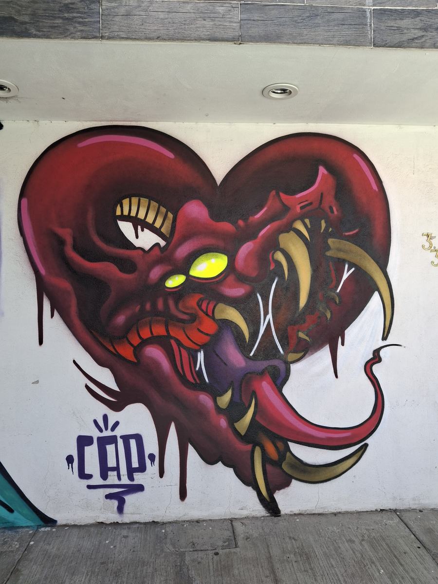 Mural de un corazón con colmillos firmado por Capo.