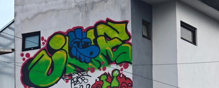 Letras de graffiti en verde y azul sobre la fachada de Canvas 90.